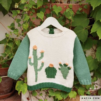 Этот очаровательный детский свитер, связанный из хлопка Katia Fair Cotton, отличается уникальным дизайном с мотивами кактусов интарсией и вышитыми деталями спереди, дополненными зелеными рукавами